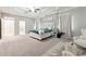 Main bedroom features tray ceilings, natural light, and a seating area for relaxation at 2410 Bridle Bridge Trl, Cumming, GA 30040