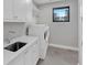 Bright laundry room with white cabinets, sink, and modern washer/dryer at 2520 Peachtree Nw Rd # 403, Atlanta, GA 30305