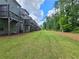 Townhome backyard featuring a green lawn with mulch beds and natural surroundings at 261 Mahone Dr, Lilburn, GA 30047