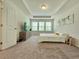 Bright bedroom featuring neutral carpet, tray ceiling, and a bed with white bedding at 261 Mahone Dr, Lilburn, GA 30047