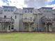 Exterior back view of townhomes with wooden balconies and well-maintained lawn at 261 Mahone Dr, Lilburn, GA 30047