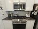 Modern kitchen with stainless steel appliances, granite countertops, and white cabinetry at 261 Mahone Dr, Lilburn, GA 30047