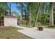 Backyard shed and patio with fire pit surrounded by green grass and trees at 300 Wesfork Nw Way, Suwanee, GA 30024