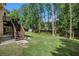 Spacious backyard featuring mature trees, lush grass, and a deck at 300 Wesfork Nw Way, Suwanee, GA 30024