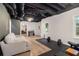 Finished basement featuring gym equipment, wood laminate flooring and exposed painted ceiling at 300 Wesfork Nw Way, Suwanee, GA 30024