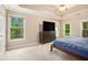 Neutral bedroom with high ceilings, carpet, windows, a large TV, and ensuite bathroom at 300 Wesfork Nw Way, Suwanee, GA 30024