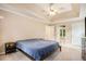 Neutral bedroom with high ceilings, ceiling fan, carpet, windows, and ensuite bathroom at 300 Wesfork Nw Way, Suwanee, GA 30024