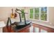 Bright exercise room with wood floors, a treadmill, guitars, and dumbbells for a complete at-home workout experience at 300 Wesfork Nw Way, Suwanee, GA 30024