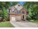 Classic two-story home boasts brick and siding exterior, a two-car garage, and mature landscaping at 300 Wesfork Nw Way, Suwanee, GA 30024