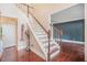 Foyer with hardwood floors and a staircase featuring white risers and stained wood handrail at 300 Wesfork Nw Way, Suwanee, GA 30024