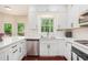 Modern kitchen featuring white cabinets, stainless steel appliances, and a window view at 300 Wesfork Nw Way, Suwanee, GA 30024