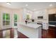Sunlit kitchen with white island, modern appliances and exterior access at 300 Wesfork Nw Way, Suwanee, GA 30024