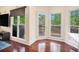View from the living area to the backyard deck and yard with large glass windows and a door at 300 Wesfork Nw Way, Suwanee, GA 30024