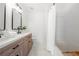 Modern bathroom featuring a double sink vanity, with black hardware, and tub with shower at 1135 Kilmington Ct, Alpharetta, GA 30009