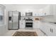 Modern kitchen with stainless steel appliances, white cabinetry, and marble countertops at 1135 Kilmington Ct, Alpharetta, GA 30009