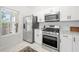 Well-lit kitchen featuring stainless steel appliances, white cabinets and marble counter tops at 1135 Kilmington Ct, Alpharetta, GA 30009
