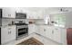Modern kitchen with stainless steel appliances, white cabinets, and marble floors at 1135 Kilmington Ct, Alpharetta, GA 30009