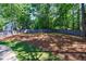 A beautifully landscaped backyard with a lush lawn, mature trees, and a wooden fence, offering privacy and tranquility at 1348 Timberland Se Dr, Marietta, GA 30067