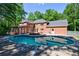 A stunning backyard featuring a pristine pool, beautiful brick house, and lush greenery, perfect for outdoor enjoyment at 1348 Timberland Se Dr, Marietta, GA 30067