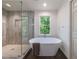 Bright bathroom with a freestanding tub and shower with frameless glass door; serene and stylish at 1348 Timberland Se Dr, Marietta, GA 30067