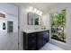 Stylish bathroom with a sleek vanity, large mirror, and a window offering a picturesque view of lush greenery at 1348 Timberland Se Dr, Marietta, GA 30067