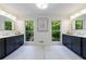 Bright bathroom featuring double vanities, large mirrors, and views of lush trees at 1348 Timberland Se Dr, Marietta, GA 30067