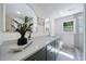 Modern bathroom with dual vanity, quartz counters, framed mirrors and a tiled shower with glass door at 1348 Timberland Se Dr, Marietta, GA 30067