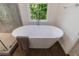 A modern white soaking tub positioned in front of a window with a view of the outdoor greenery at 1348 Timberland Se Dr, Marietta, GA 30067