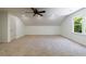 Bright bonus room featuring neutral carpet, fresh white paint, a ceiling fan, and a window with views of foliage at 1348 Timberland Se Dr, Marietta, GA 30067