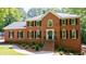 Charming brick home with symmetrical design, lush landscaping, and a welcoming entrance staircase at 1348 Timberland Se Dr, Marietta, GA 30067