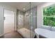 Glass enclosed shower and soaking tub with view of green trees through window at 1348 Timberland Se Dr, Marietta, GA 30067