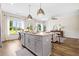 Kitchen features a large island with bar stools, modern pendant lighting, stainless steel appliances, and hardwood floors at 217 Starr Cir, Stockbridge, GA 30281