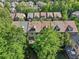 Back aerial view of townhomes with cozy patios amidst lush, mature trees at 306 Nottaway Ln, Alpharetta, GA 30009