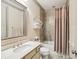 Neutral bathroom featuring a decorative mirror, a toilet, and a shower-tub combination at 306 Nottaway Ln, Alpharetta, GA 30009