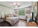 Bedroom features hardwood floors, a ceiling fan, and a large window view at 306 Nottaway Ln, Alpharetta, GA 30009