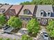 Aerial view of townhomes with landscaped front yards and a two-car garage at 306 Nottaway Ln, Alpharetta, GA 30009