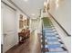 Inviting hallway with hardwood floors, staircase, elegant console table and decorative wall art at 306 Nottaway Ln, Alpharetta, GA 30009