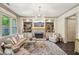 Elegant living room boasts a stone fireplace, built-in bookshelves, and large windows for plenty of natural light at 306 Nottaway Ln, Alpharetta, GA 30009
