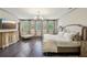 Bright main bedroom with a TV, hardwood floors, a chandelier, and custom window treatments at 306 Nottaway Ln, Alpharetta, GA 30009
