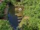 Aerial view of a serene pond with a fountain, surrounded by lush greenery at 306 Nottaway Ln, Alpharetta, GA 30009