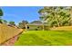 Large backyard with a green lawn, wooden fence, and covered porch at 6022 Fieldcrest Dr, Morrow, GA 30260