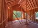 Interior view through wall framing with exterior backyard and trees visible at 6740 Pannell Rd, Buford, GA 30518