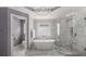 Bright bathroom with a soaking tub, glass-enclosed shower, and lovely marble tiling at 10410 High Falls Cir, Alpharetta, GA 30022
