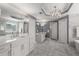 Modern bathroom featuring a large vanity, marble tile, mirrors, and a lovely chandelier at 10410 High Falls Cir, Alpharetta, GA 30022