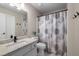 Bathroom featuring a shower with a stylish curtain, granite countertop, and tile flooring at 10410 High Falls Cir, Alpharetta, GA 30022