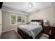 Comfortable bedroom with a dark wood bed, neutral walls, and natural light from the windows at 10410 High Falls Cir, Alpharetta, GA 30022