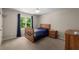 Cozy bedroom with a wood bed frame, bedside table, and natural light from the window at 10410 High Falls Cir, Alpharetta, GA 30022