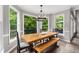 Dining area with an exposed wood table and views of the backyard and deck at 10410 High Falls Cir, Alpharetta, GA 30022