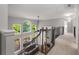 Bright hallway with large windows, overlooking the living room area below, and a beautiful staircase at 10410 High Falls Cir, Alpharetta, GA 30022