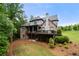 Landscaped backyard featuring a large brick home with a deck overlooking the lawn at 12980 Overlook Pass, Roswell, GA 30075